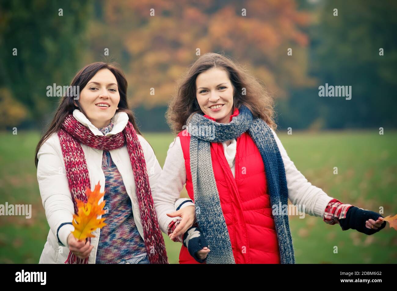 Two pretty girls walking in the park Stock Photo - Alamy