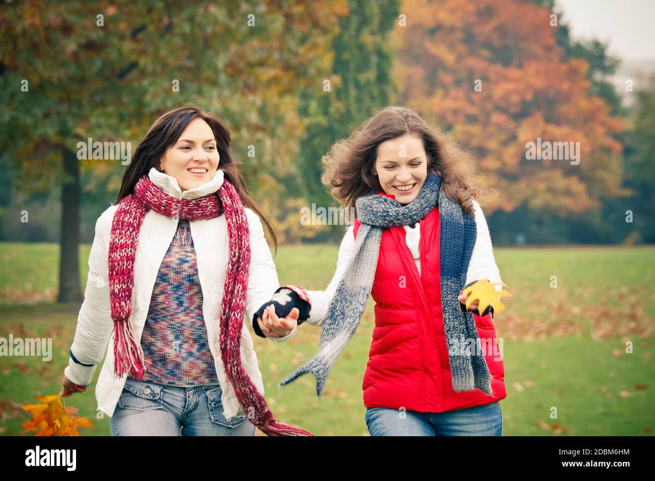 Two pretty girls walking in the park Stock Photo - Alamy