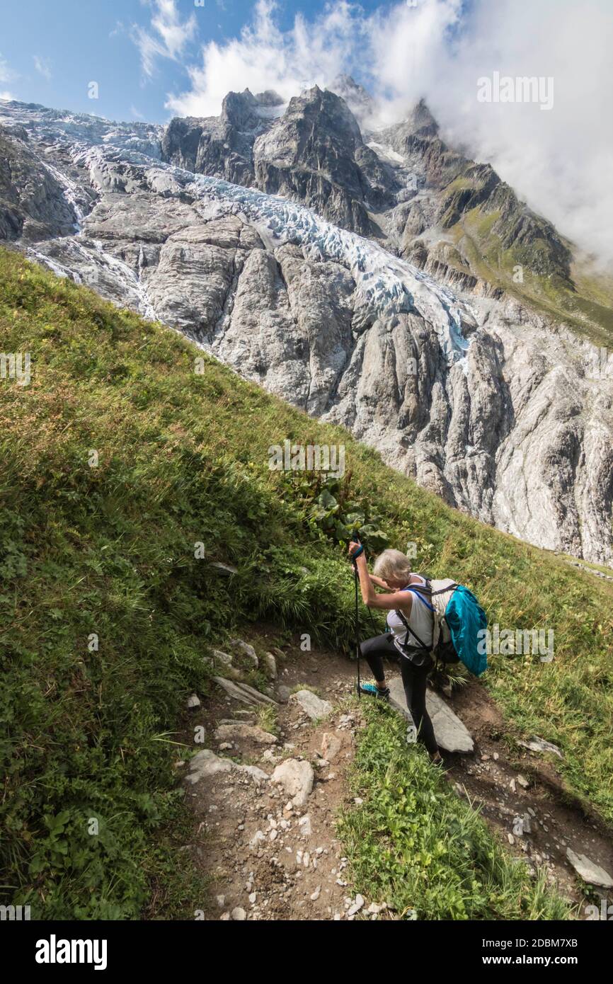 Senior woman hiking alongÃ‚Â HauteÃ‚Â Route Traverse,Ã‚Â MontÃ‚Â BlancÃ‚Â massif, Switzerland Stock Photo