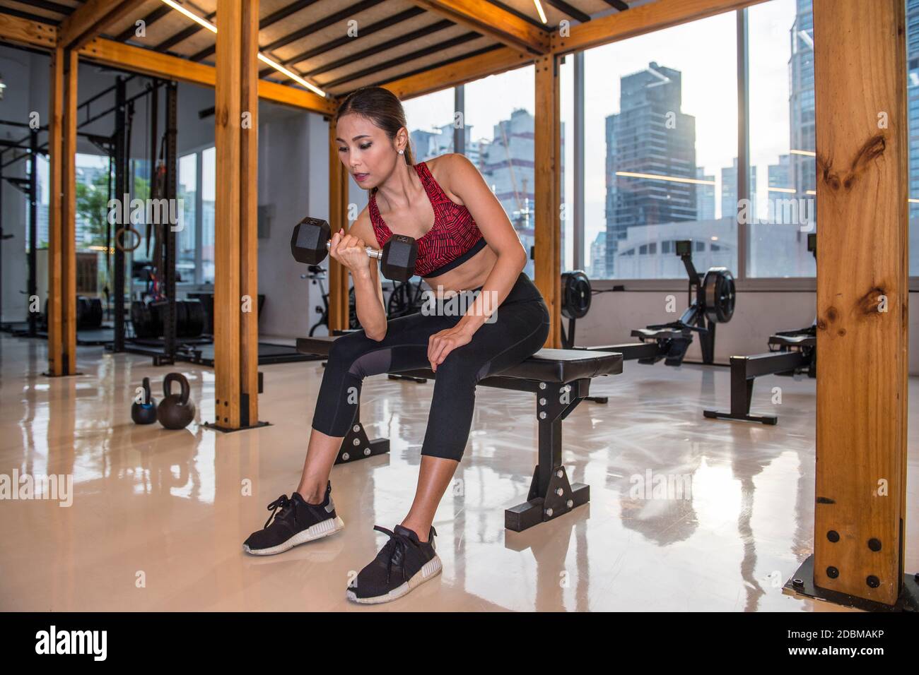 Woman exercising with dumbbell in gym Stock Photo