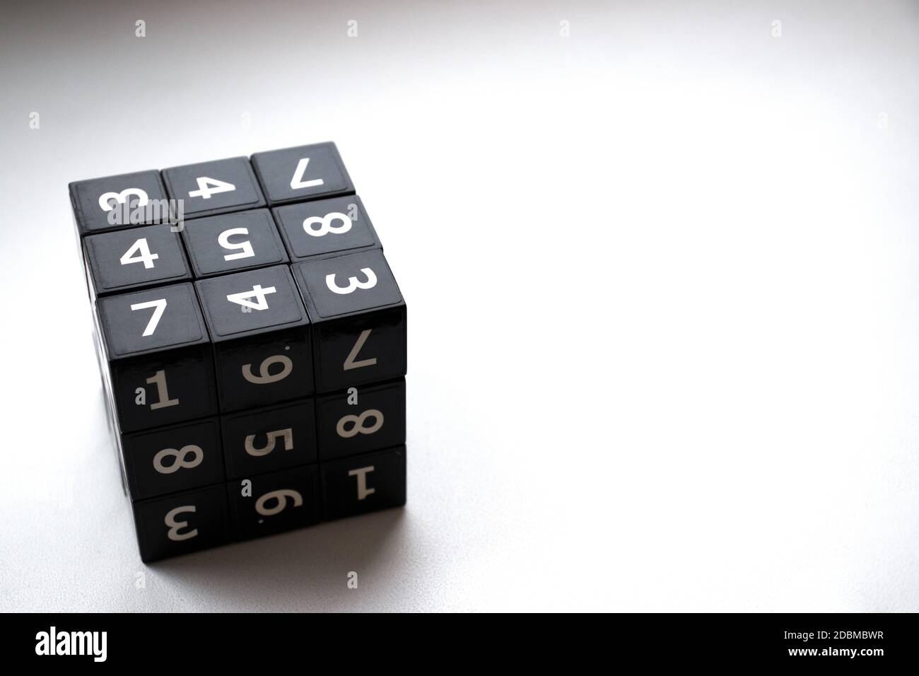 Black cube with numbers in its area for playing the Japanese Sudoku game on a white background Stock Photo