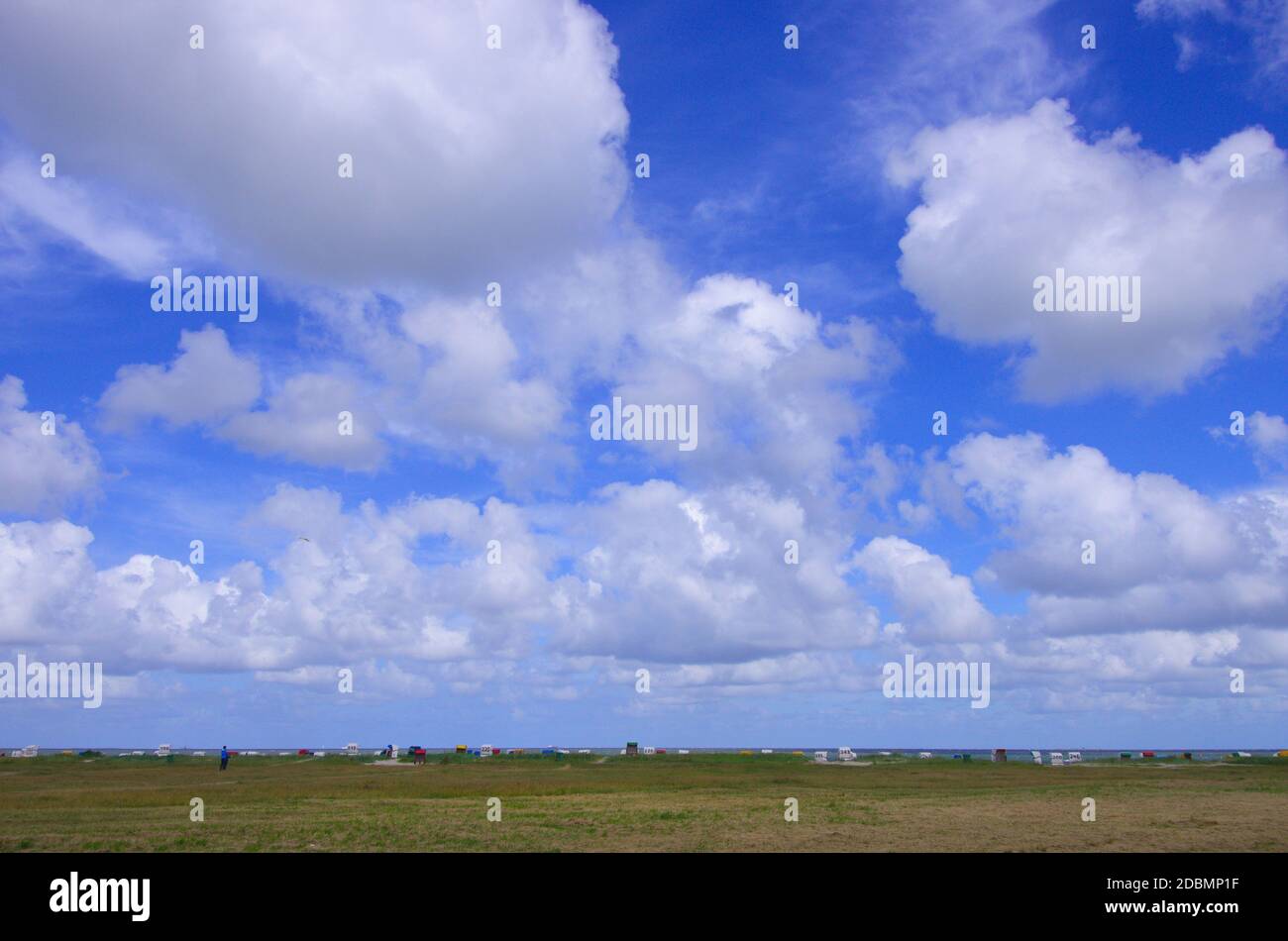 Panorama an der Nordsee von Dünen mit Strandkörben und Wolken am blauen Himmel Stock Photo