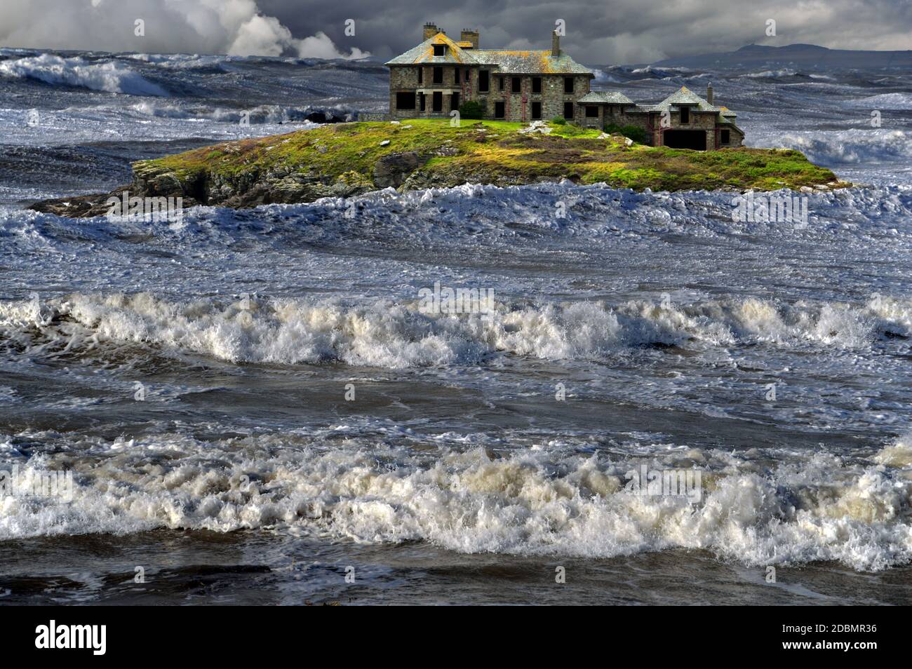 This fantasy image of a spooky island and house in wild weather is based on Craig y Mor in Trearddur Bay on Holy Island, Anglesey, North Wales. Stock Photo