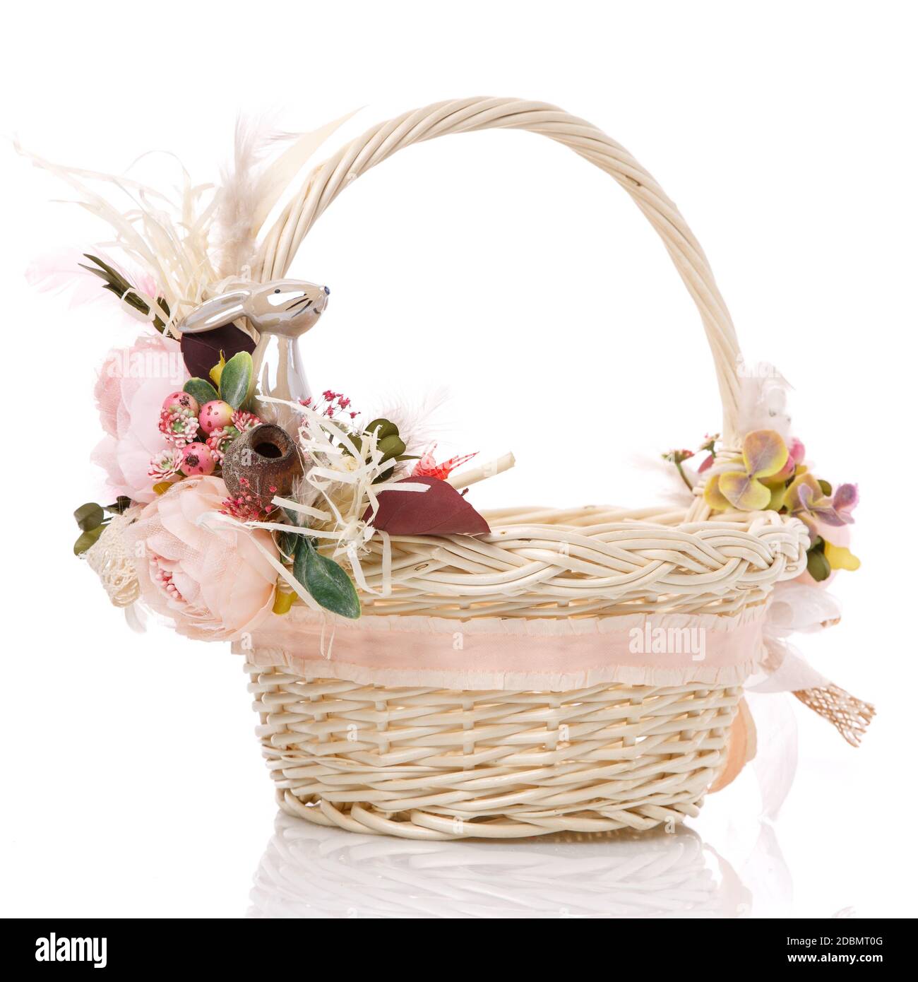 Easter basket on white background. Decorated with pink flowers and a ...