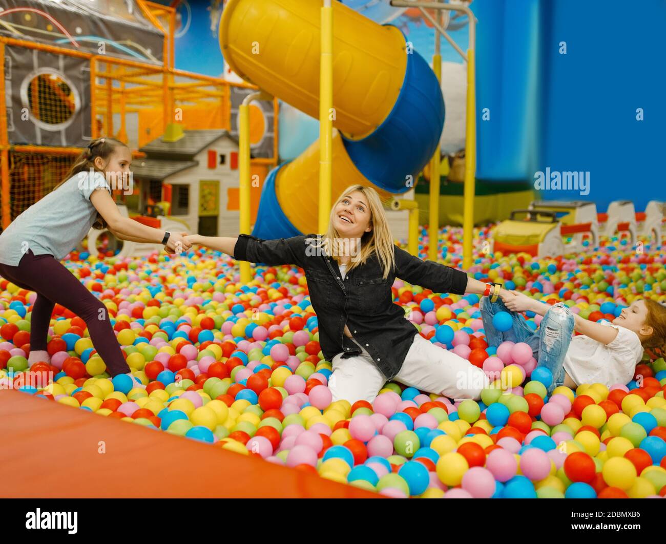 Children plays with mother in the entertainment center. Mom and her