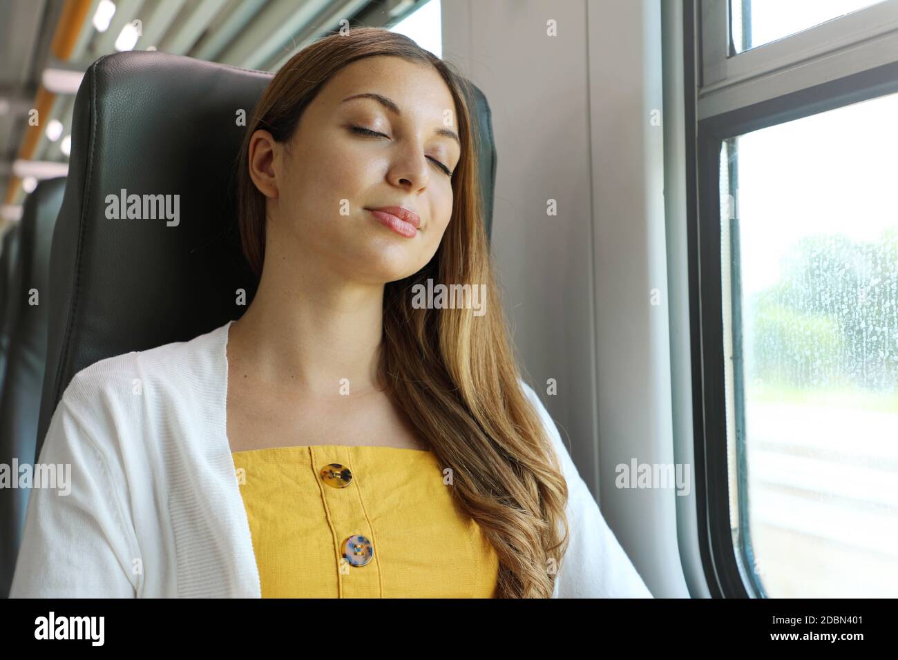 Tired business woman sleeping sitting in the train after a day of work . Train passenger traveling sitting relaxed and sleeping. Stock Photo