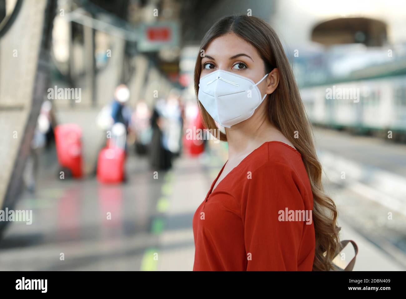 Portrait of casual woman waiting train with KN95 FFP2 protective mask at train station Stock Photo