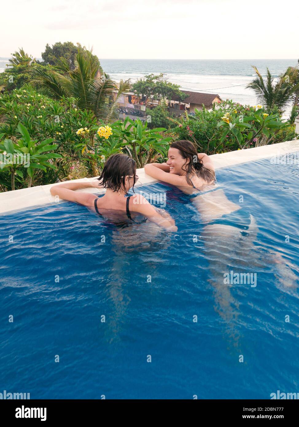 Two women in swimming pool in hotel,Ã‚Â Balian, Bali, Indonesia Stock Photo