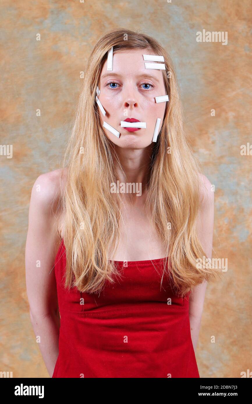 Young beautiful woman silenced with sticky tape patches Stock Photo