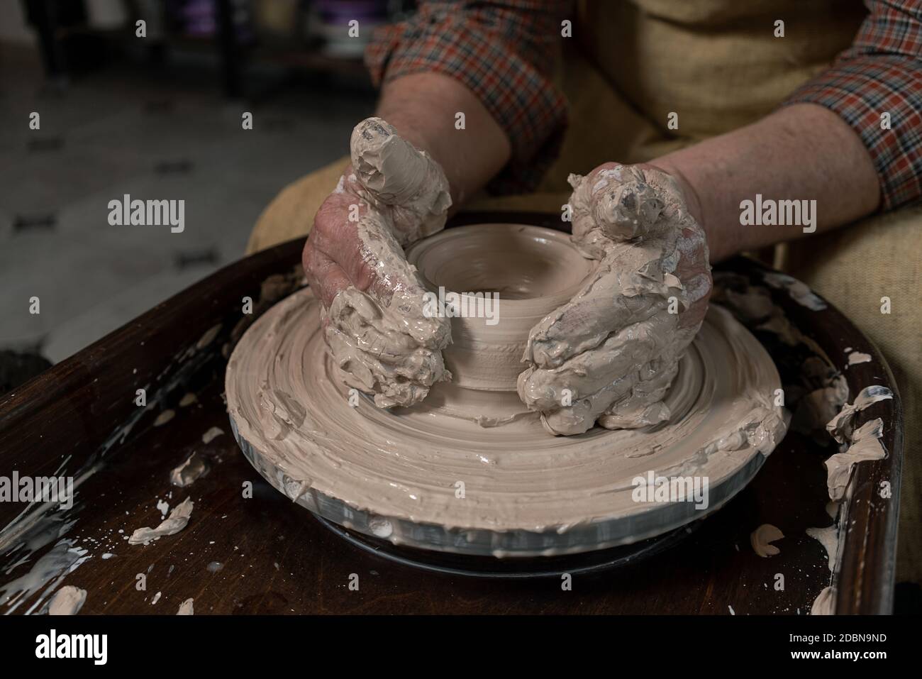 close-up of a Potter's hand sculpts a pot pitcher of clay on a Potter's wheel Stock Photo
