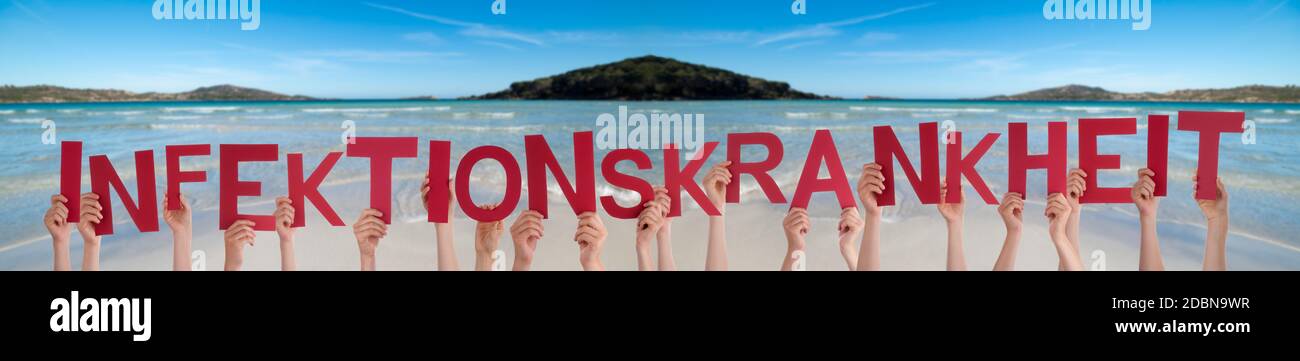 People Hands Holding Red German Word Infektionskrankheit Means Infection Sickness. Ocean And Beach As Background Stock Photo