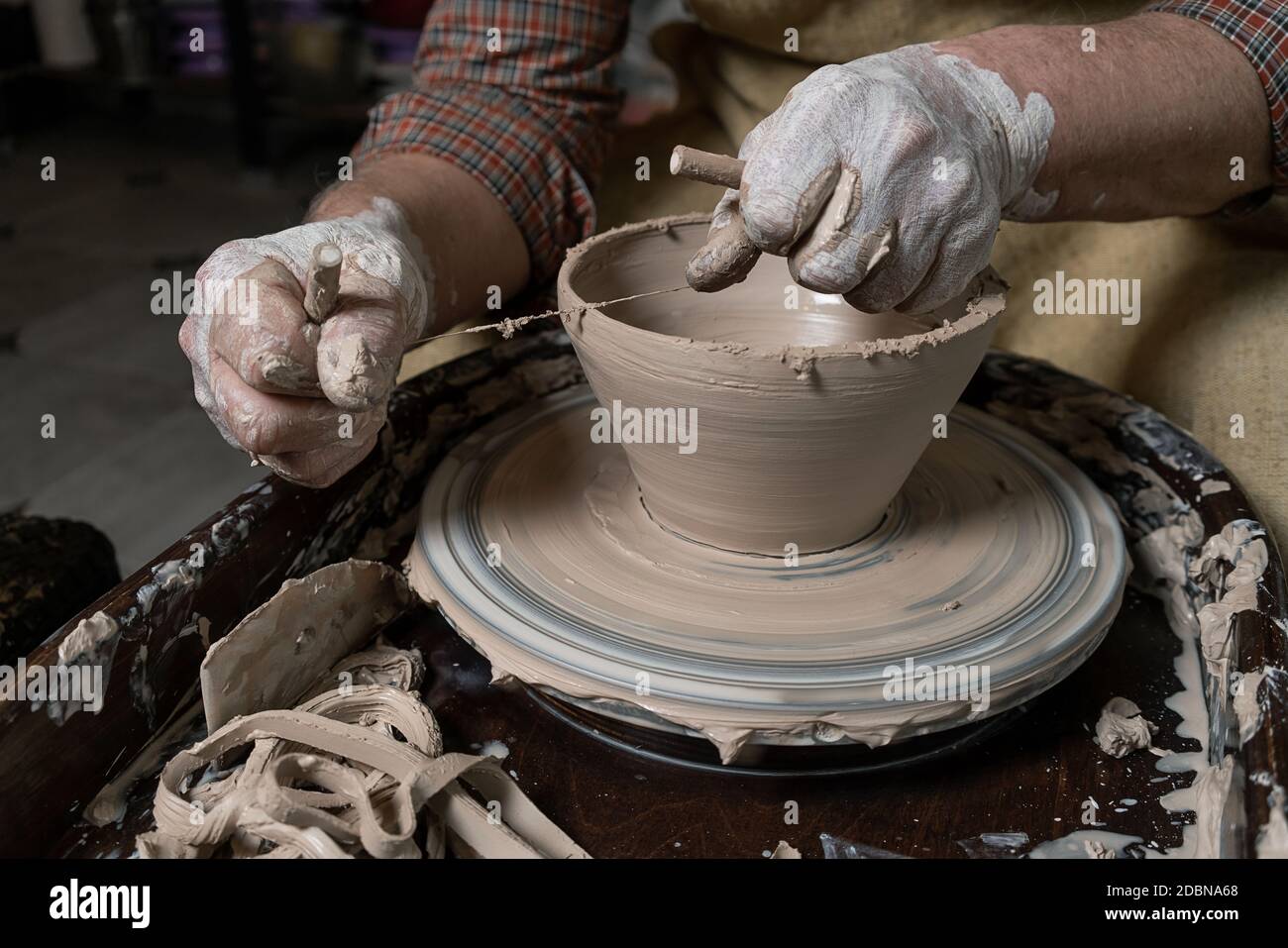 close-up of a Potter's hand sculpts a pot pitcher of clay on a Potter's wheel Stock Photo