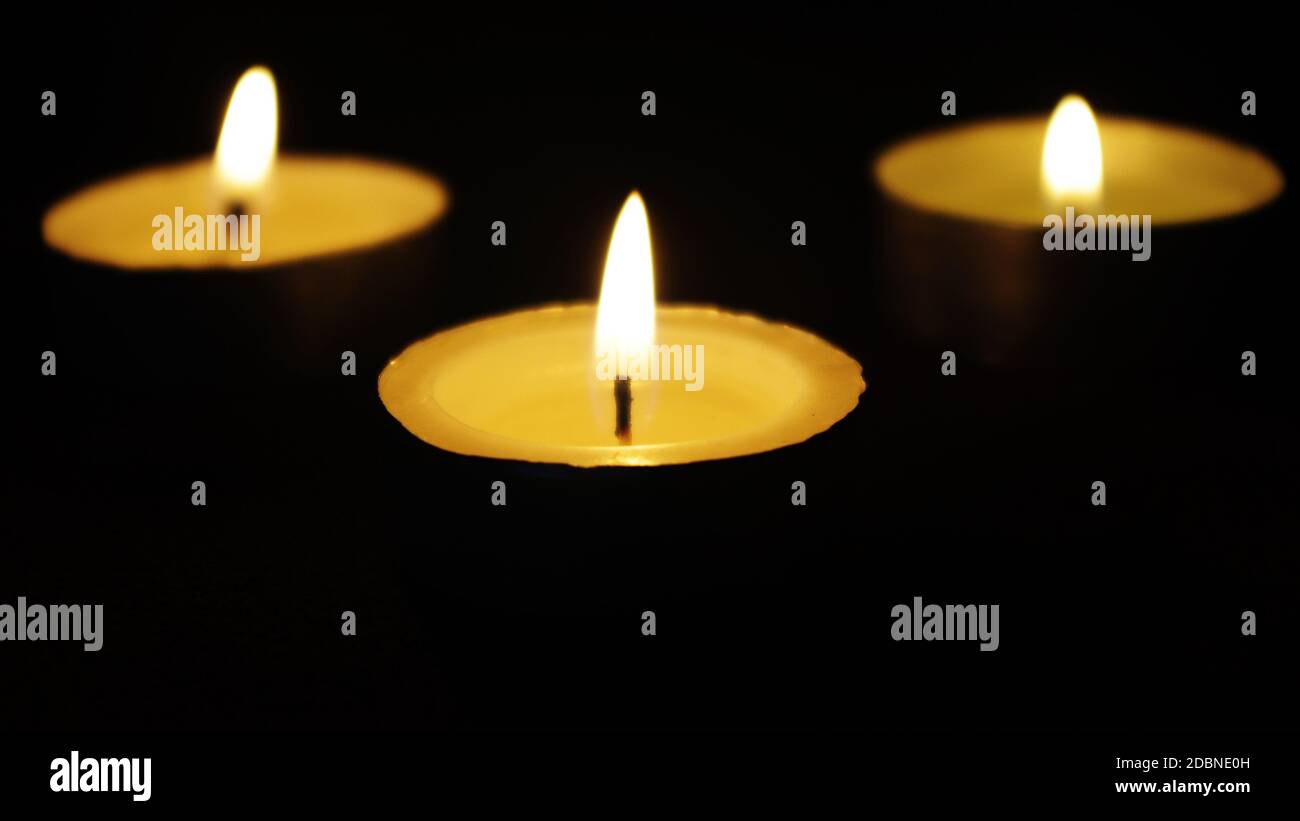 three memorial candles in darkness Stock Photo Alamy
