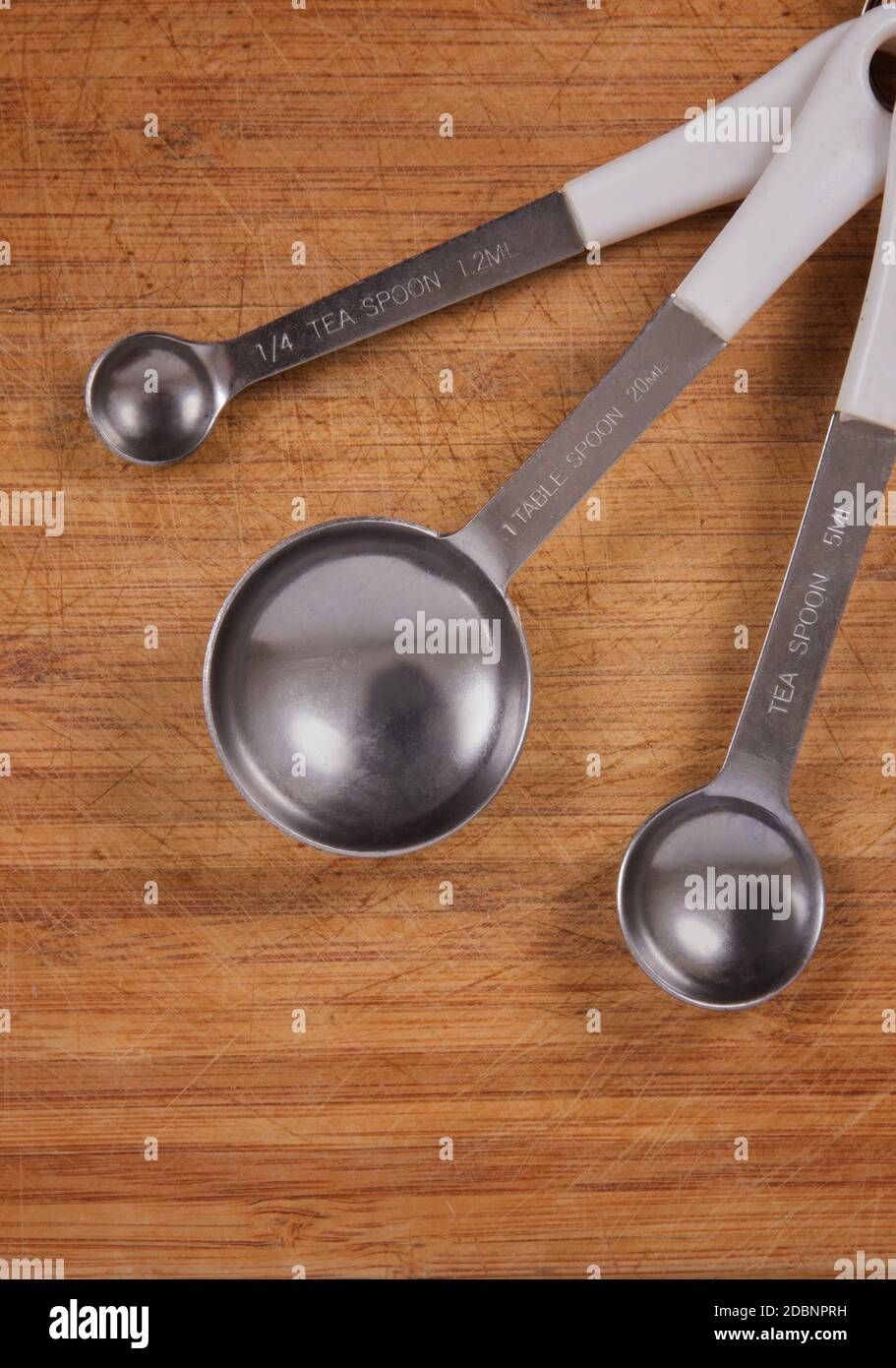 tea spoons over wooden kitchen table Stock Photo