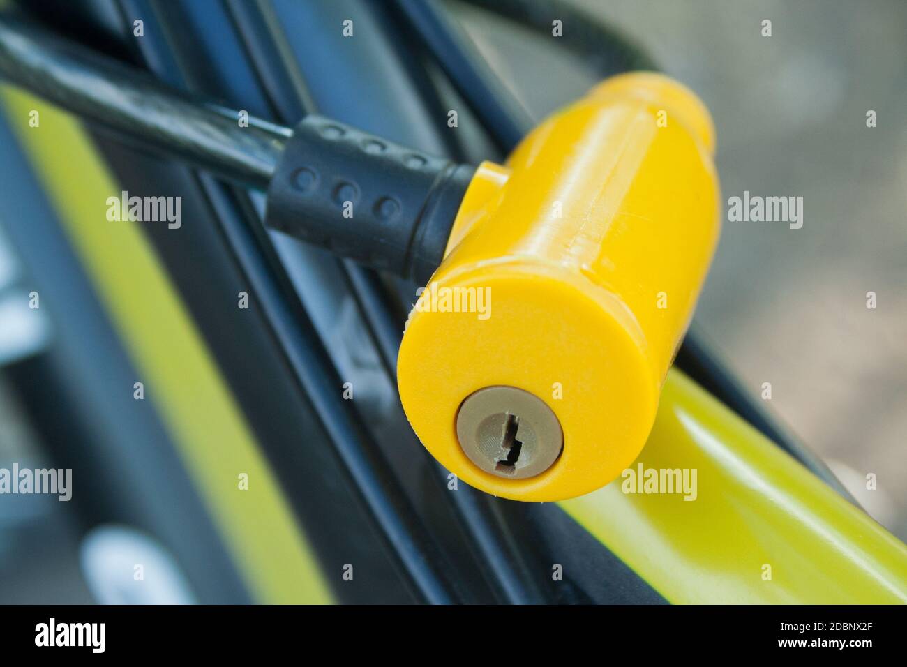 Yellow plastic lock fixed on a bicycle close up Stock Photo
