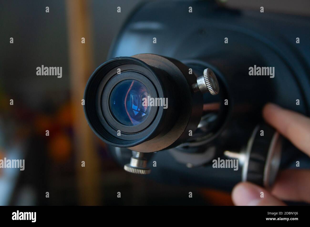 Close up of eyepiece of telescope with man's hand. Telescope tuning