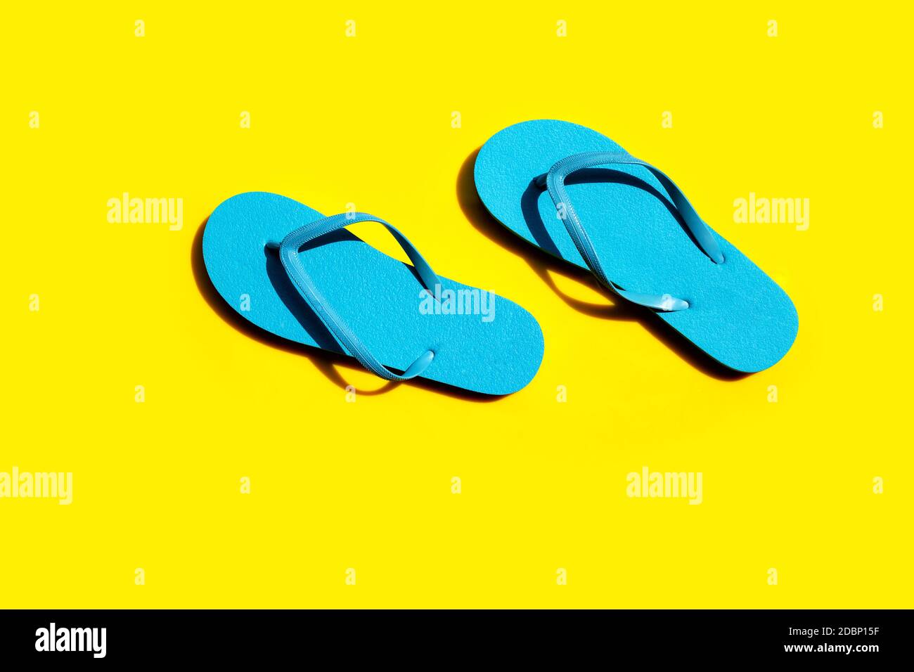 Blue flip flops on yellow background. Top view Stock Photo - Alamy