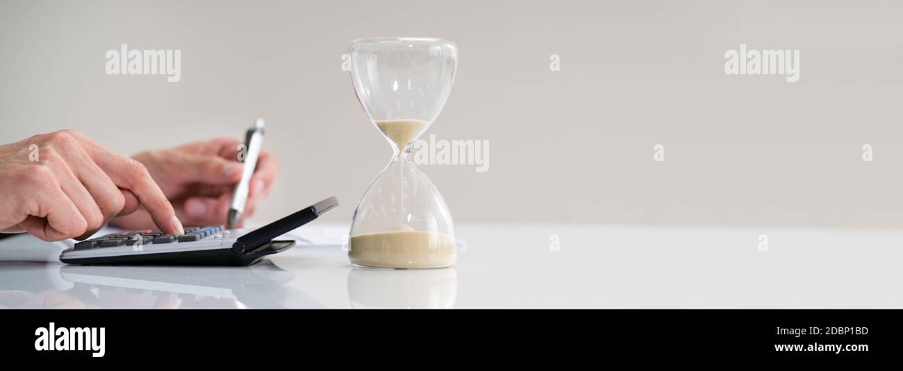 Late Invoice And Hourglass Deadline Working In Office Stock Photo