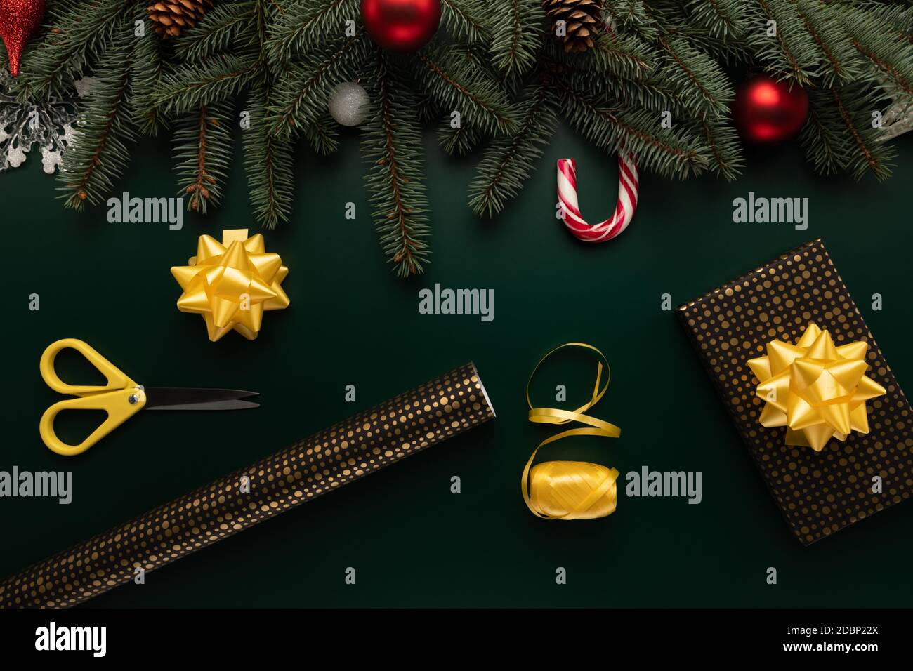 On a table decorated with Christmas decor, there are items needed for gift wrapping. Stock Photo