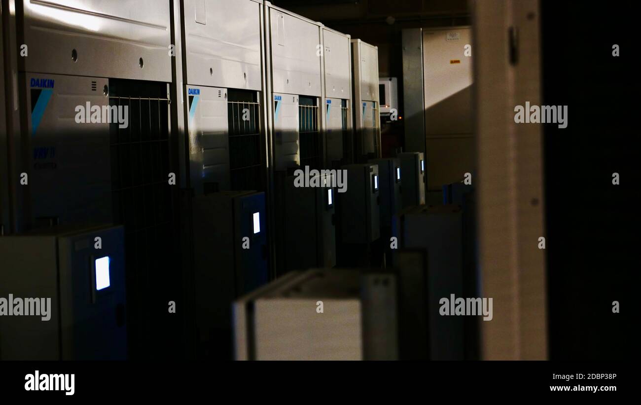 Dimly lit room full of electrical wiring and servers beneath a