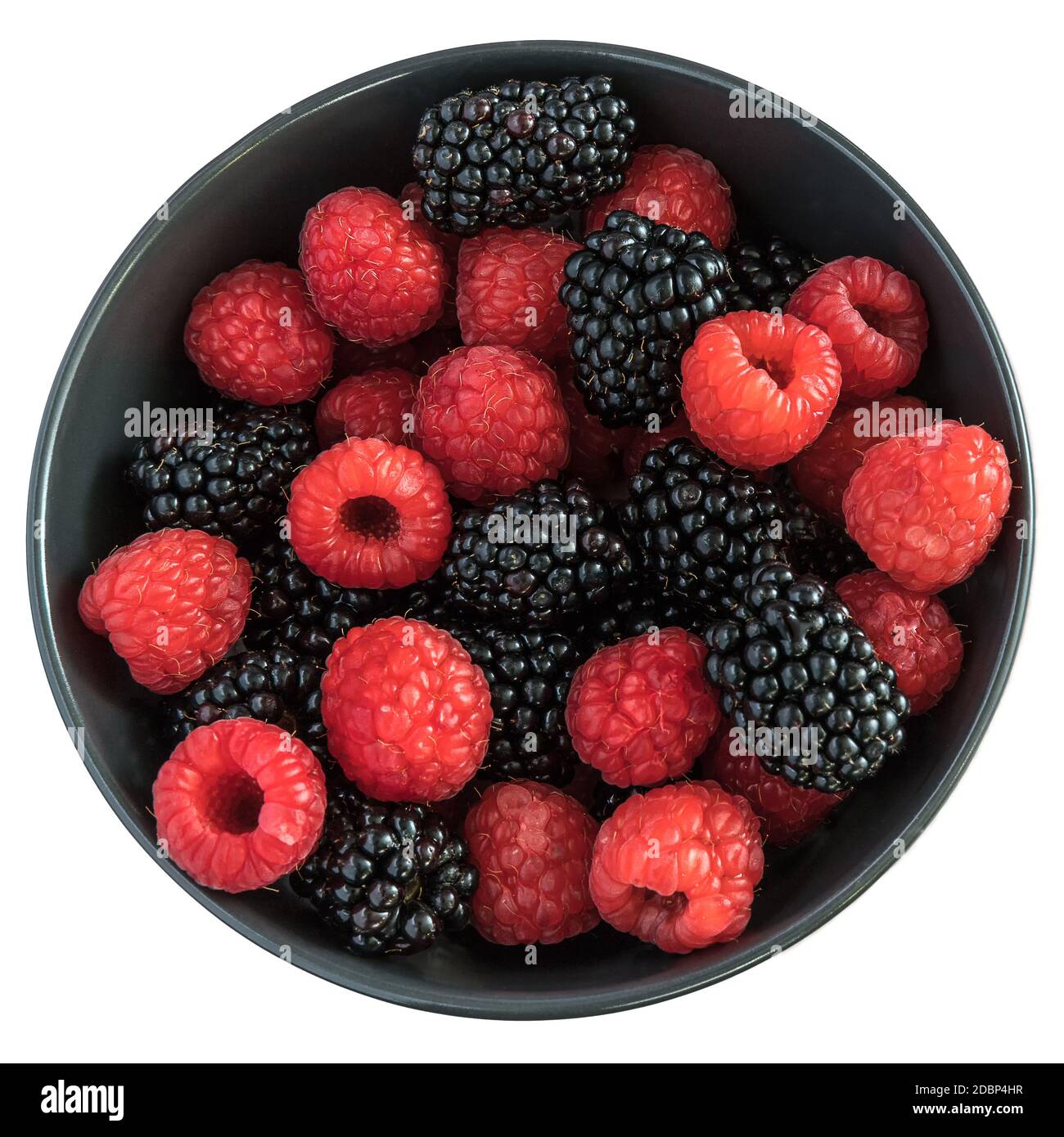 Blackberries and raspberries in a black bowl. Light pink background ...