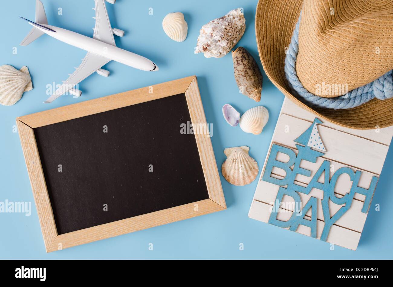 Empty chalkboard with seashells and decorative airplane. Summer travel concept. Top view, flat lay. Copy Space. Mock up. Stock Photo