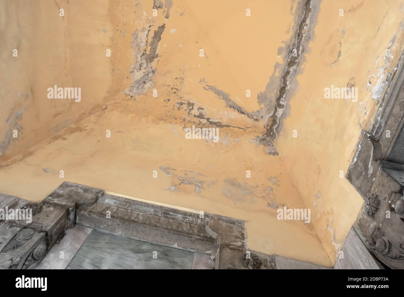 Peeling paint on an interior ceiling a result of humidity Stock Photo