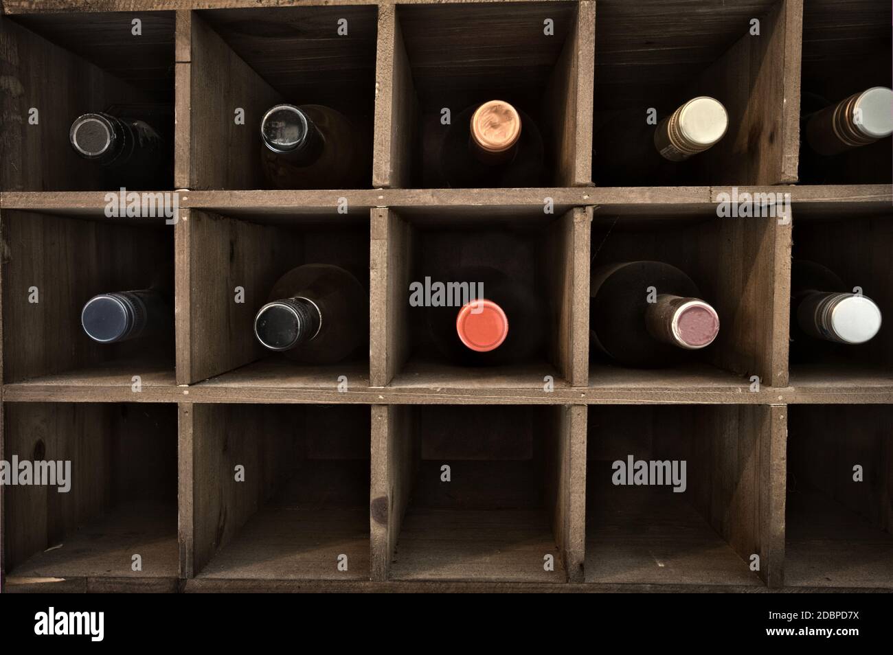 Collection of wine in wooden wine rack in a wine cellar, retro vintage