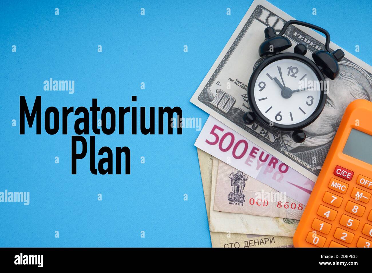MORATORIUM PLAN text with alarm clock, banknotes currencies and calculator on blue background. Coronavirus Covid19 and Business Concept Stock Photo