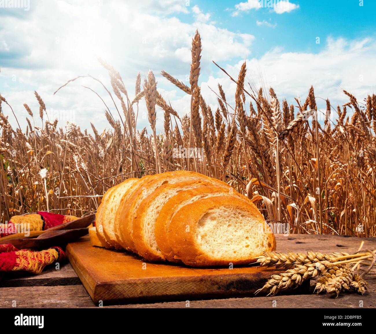 Bread on the table in wheat field Stock Photo - Alamy