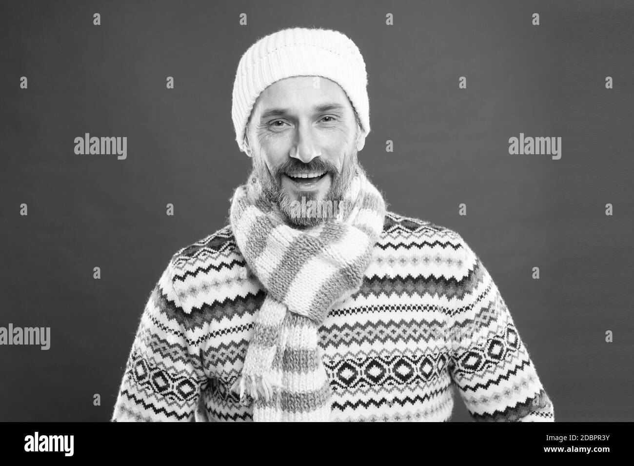 Winter fashion trends for mature adult. Mature man red background. Mature person in cold weather fashion style. Mature vogue model. Keep cold out with warm clothing. Stock Photo