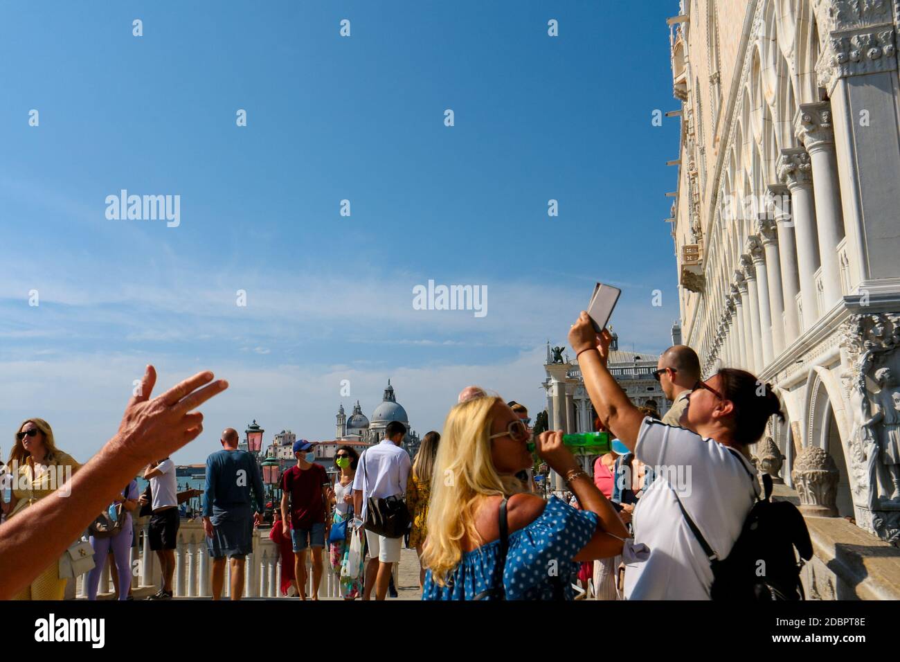 Tourism at Doge's Palace in Venice with tourists taking selfies in face masks during coronavirus crisis in Italy. Stock Photo