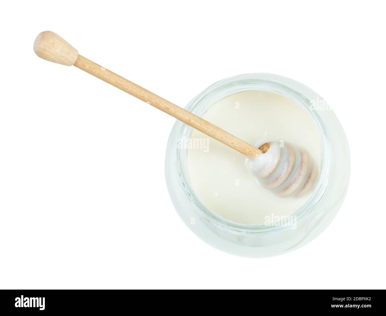 top view of wooden stick on surface of natural organic white honey in glass jar isolated on white background Stock Photo