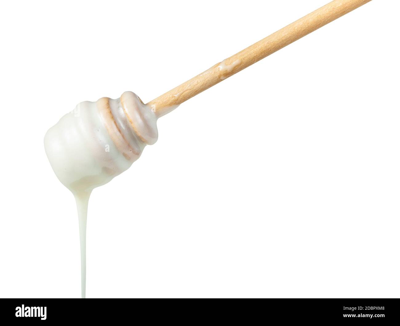 side view of natural organic white honey pouring from wooden stick close up isolated on white background Stock Photo