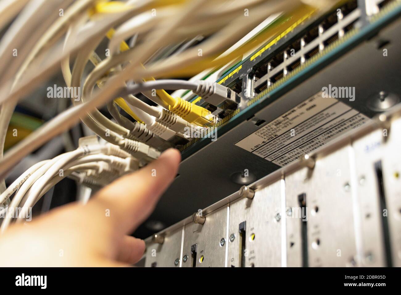 Technician pointing at cables in cables room Stock Photo
