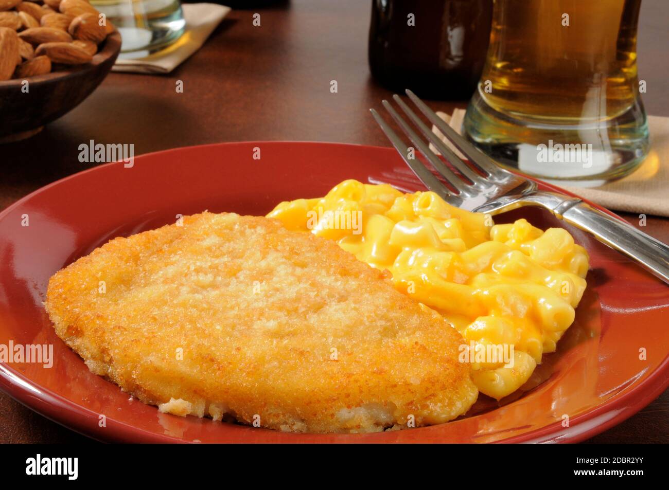 Breaded fish fillet with macaroni and cheese and beer on a bar counter Stock Photo