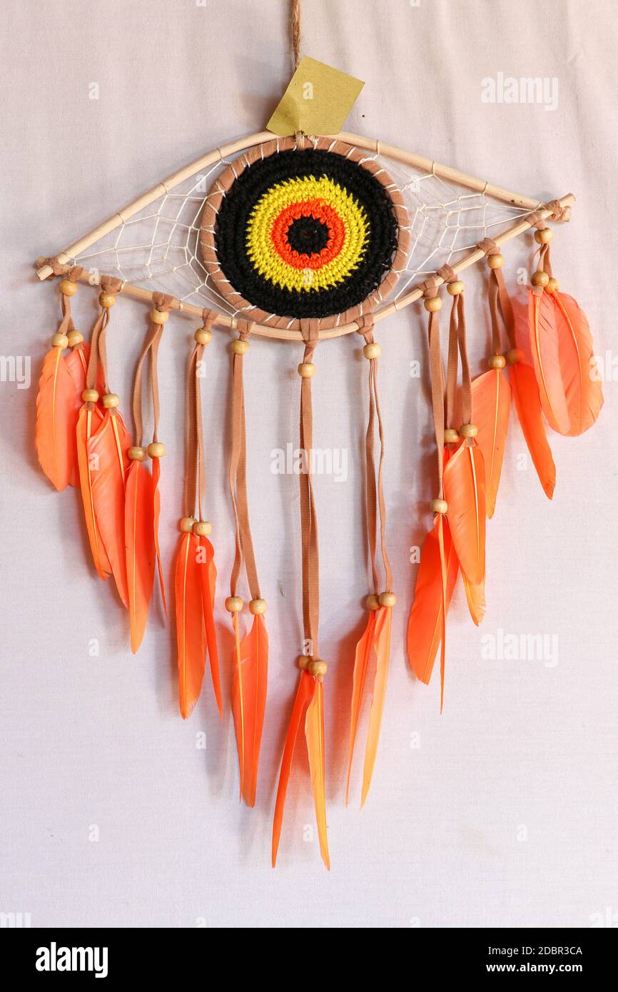 divine eye of providence dreamcatcher with colored feathers on a white background. Stock Photo