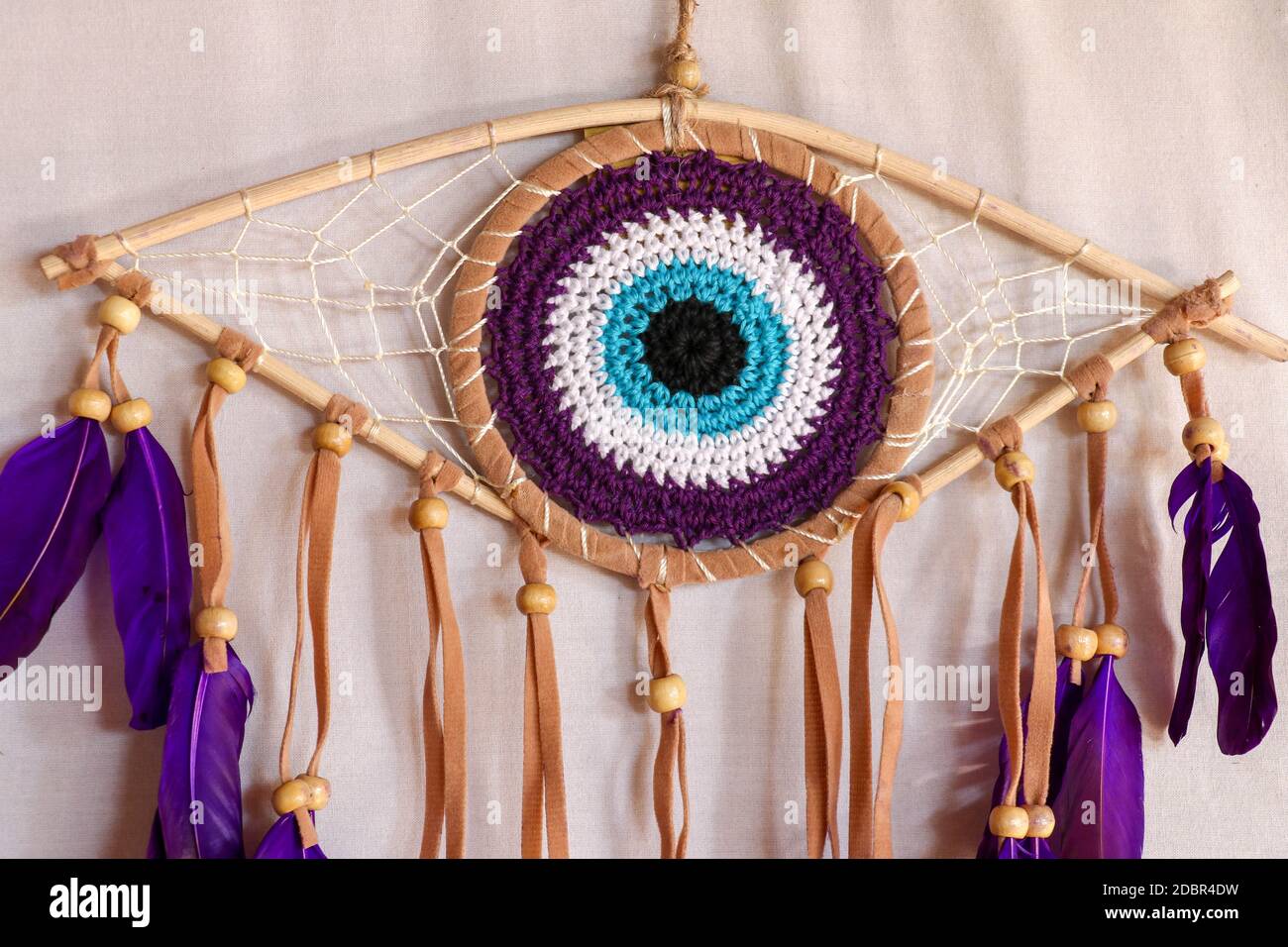 divine eye of providence dreamcatcher with colored feathers on a white background. Stock Photo