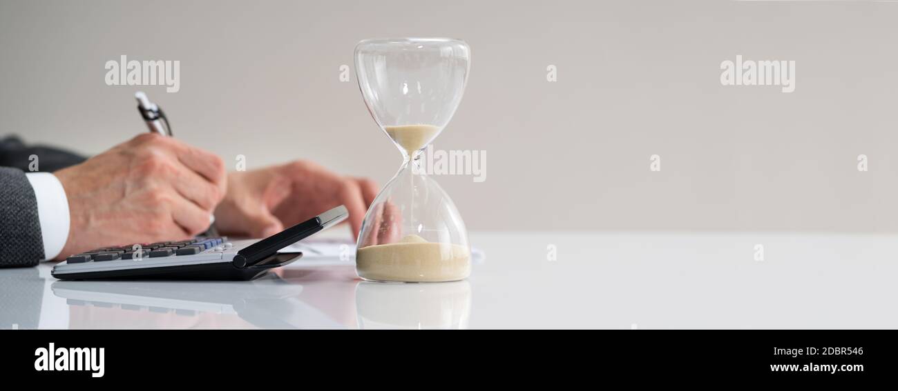 Late Invoice And Hourglass Deadline Working In Office Stock Photo