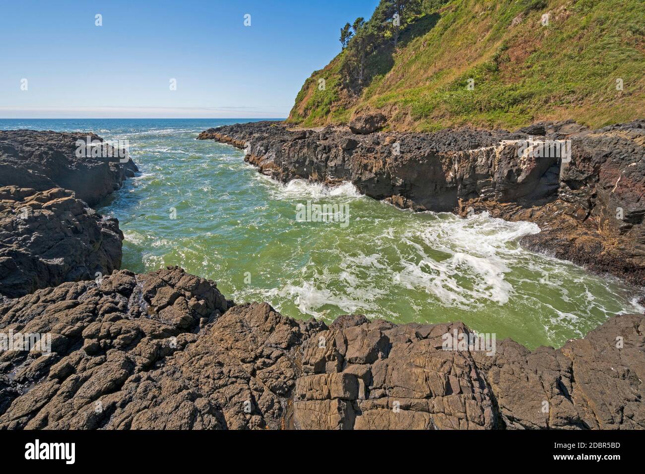 Churning Waters in a Narrow Ocean Inlet at the Devils Churn on Cape Perpetua on the Oregon Coast Stock Photo
