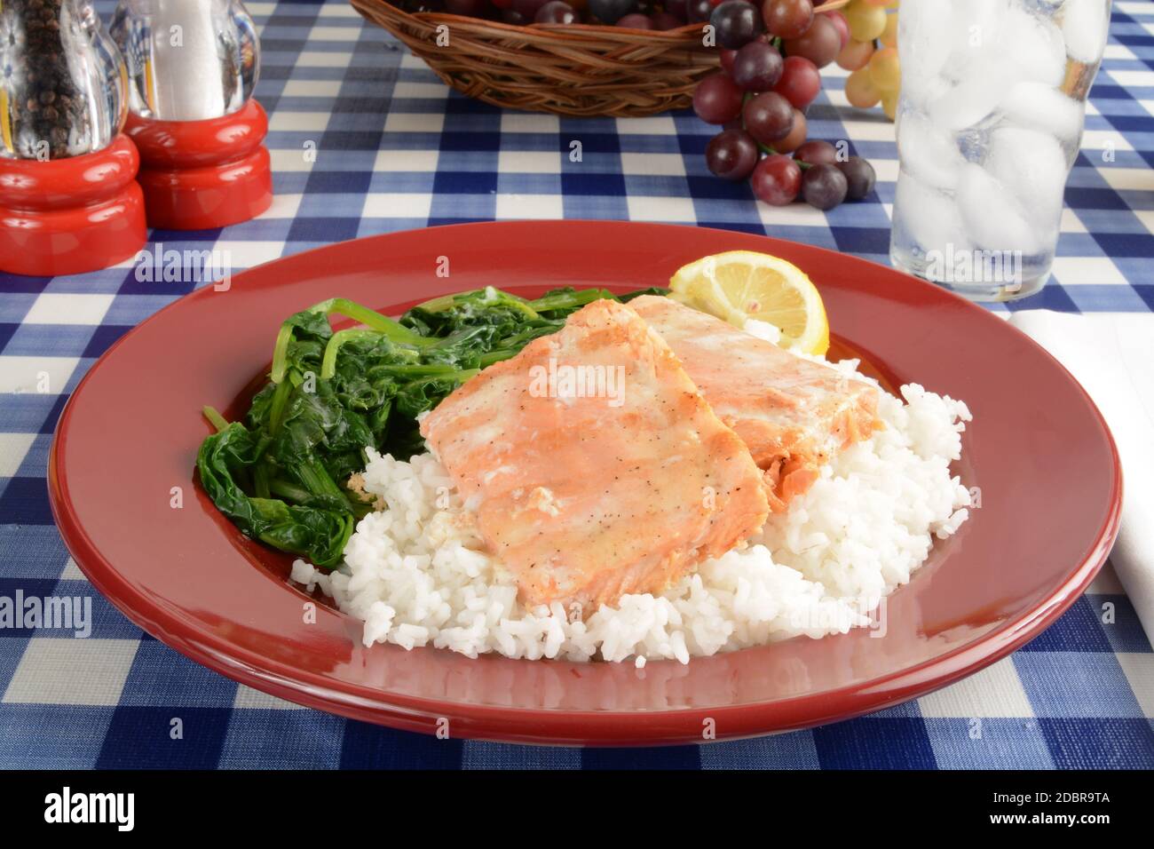Grilled salmon steaks on a bed of steamed rice with spinach Stock Photo