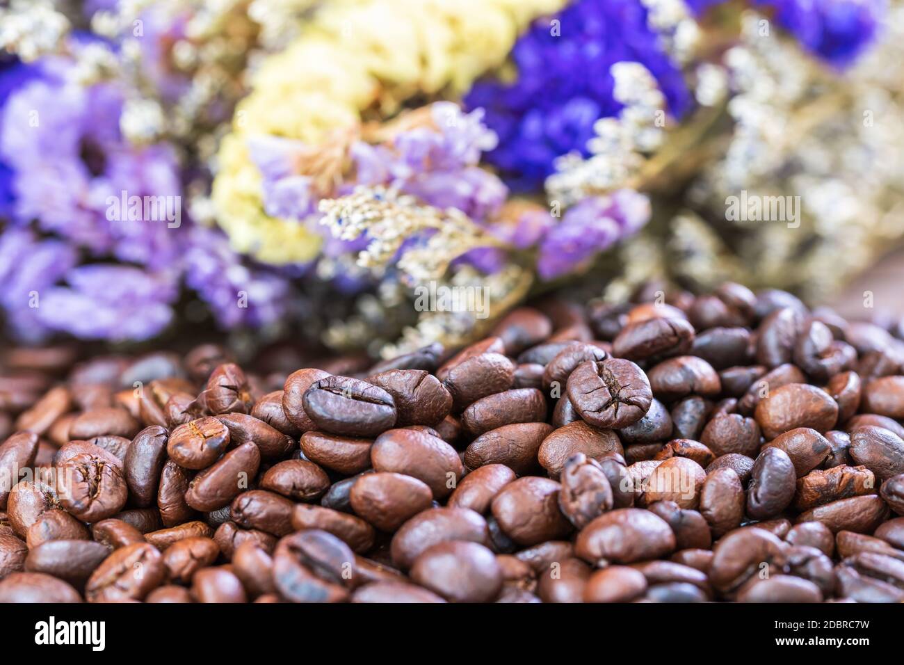 Close up roasted coffee beans heap with flower background Stock Photo ...