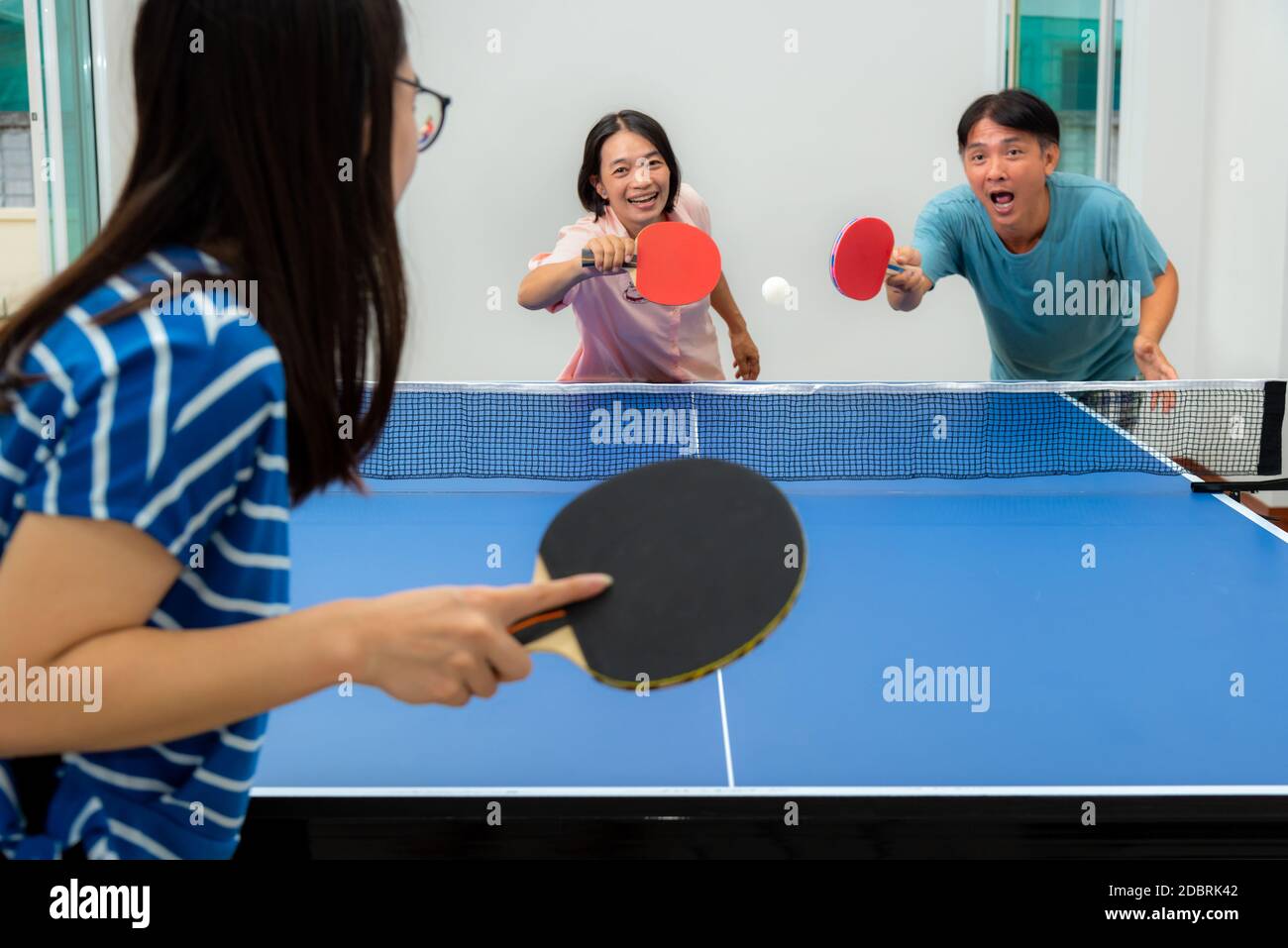 Couple fun playing table tennis or Ping pong indoor together leisure with  competing in sports games at house. Father mother and daughter Asian family  Stock Photo - Alamy