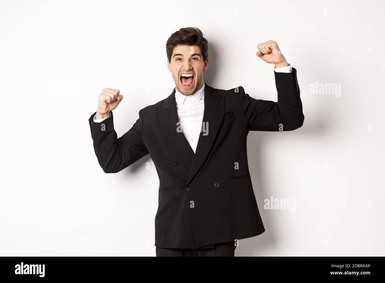 Portrait of successful businessman in black suit, become champion, raising  hands up and shouting yes, triumphing and celebrating victory, standing  Stock Photo - Alamy