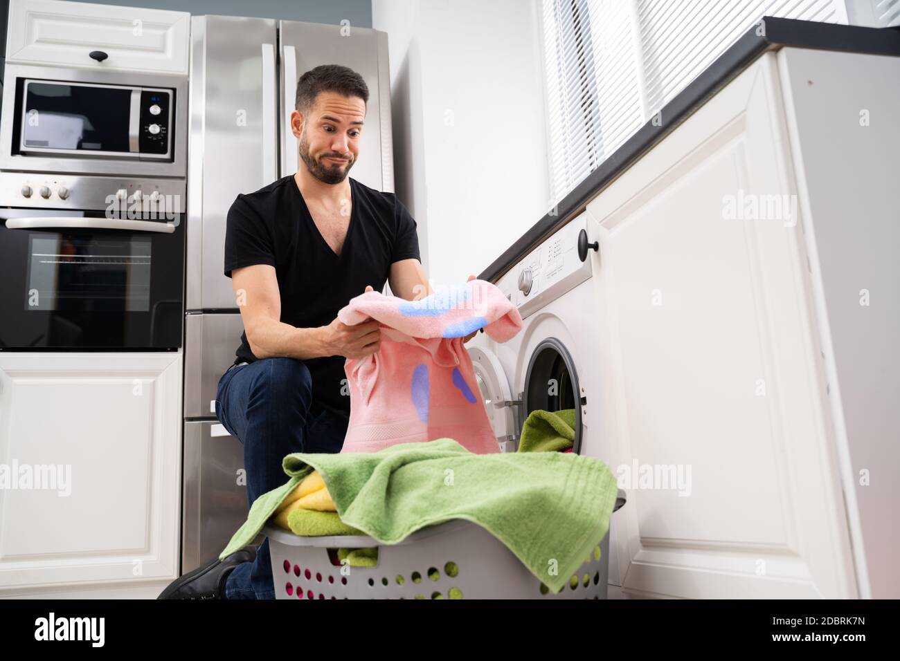 Man Doing Laundry. Stains On Clothes After Washing Machine Stock Photo