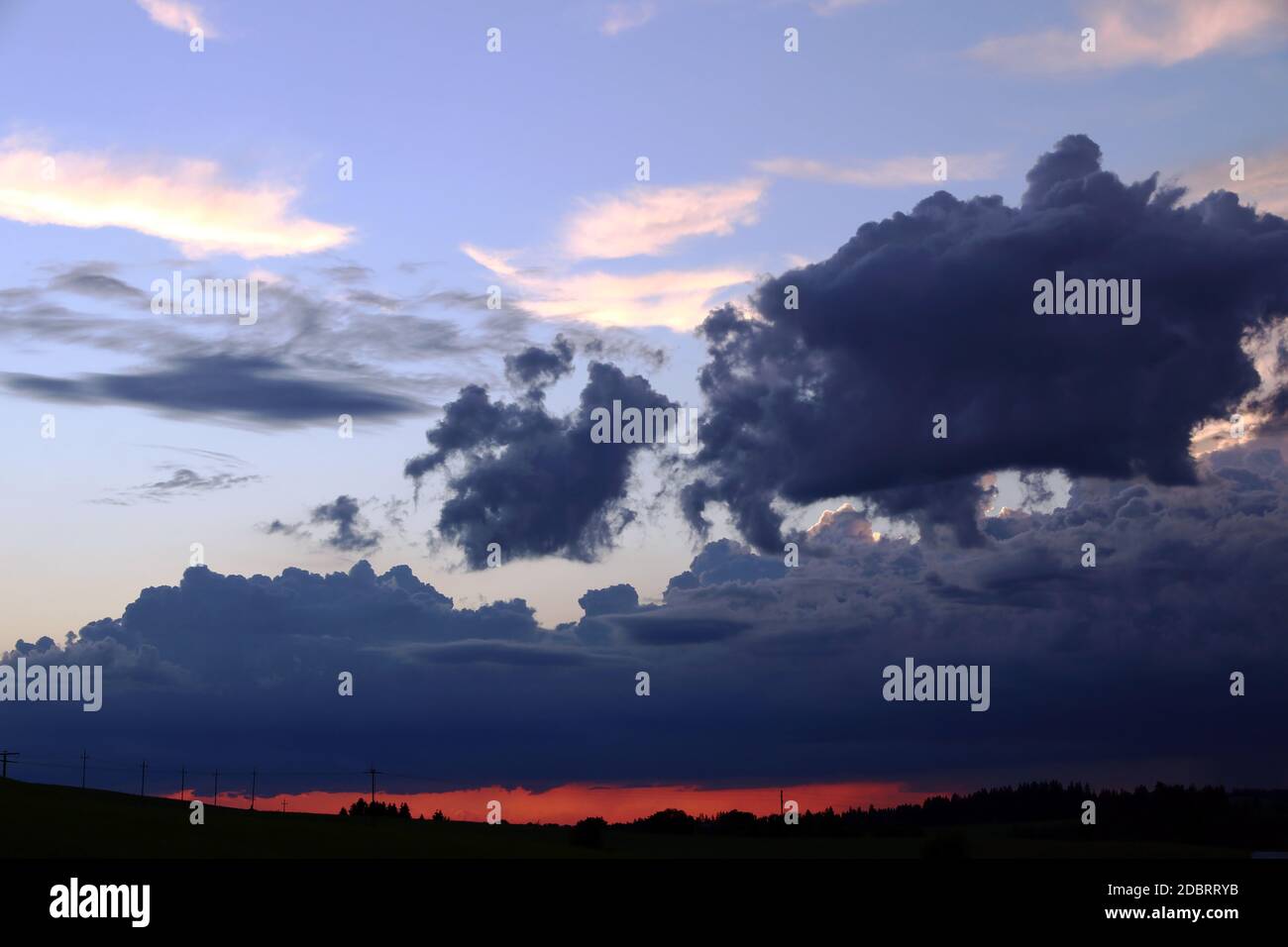 A sunset with dark rain clouds in summer Stock Photo