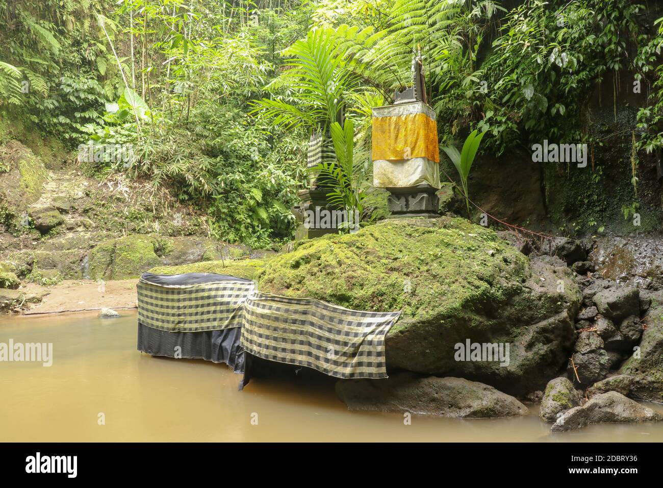 River and ancient hindu altar and Goa Giri temple in the forest Beautiful river flow surrounded by wild rainforest on a sunny summer day. Bali, Indone Stock Photo