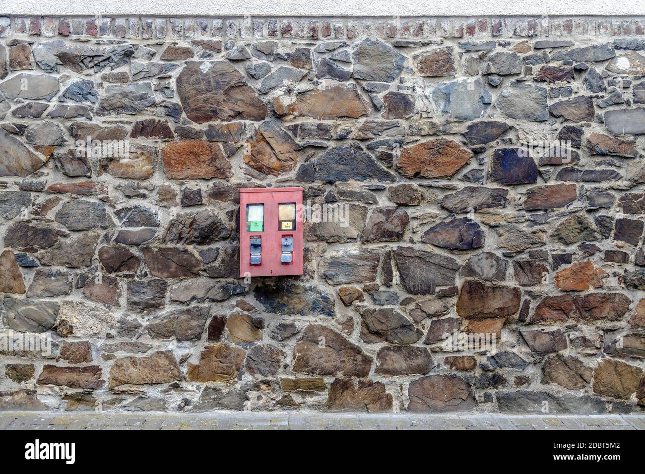 Chewing Gum Machine hanging on a brick wall facade Stock Photo