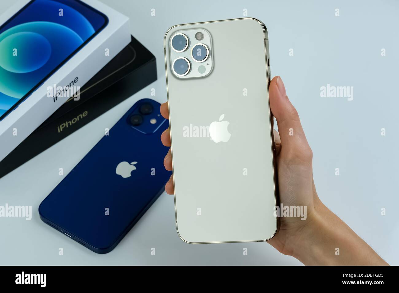 Iphone 12 Pro Max In Gold Next To Iphone 12 In Blue On A White Desk Stock Photo Alamy
