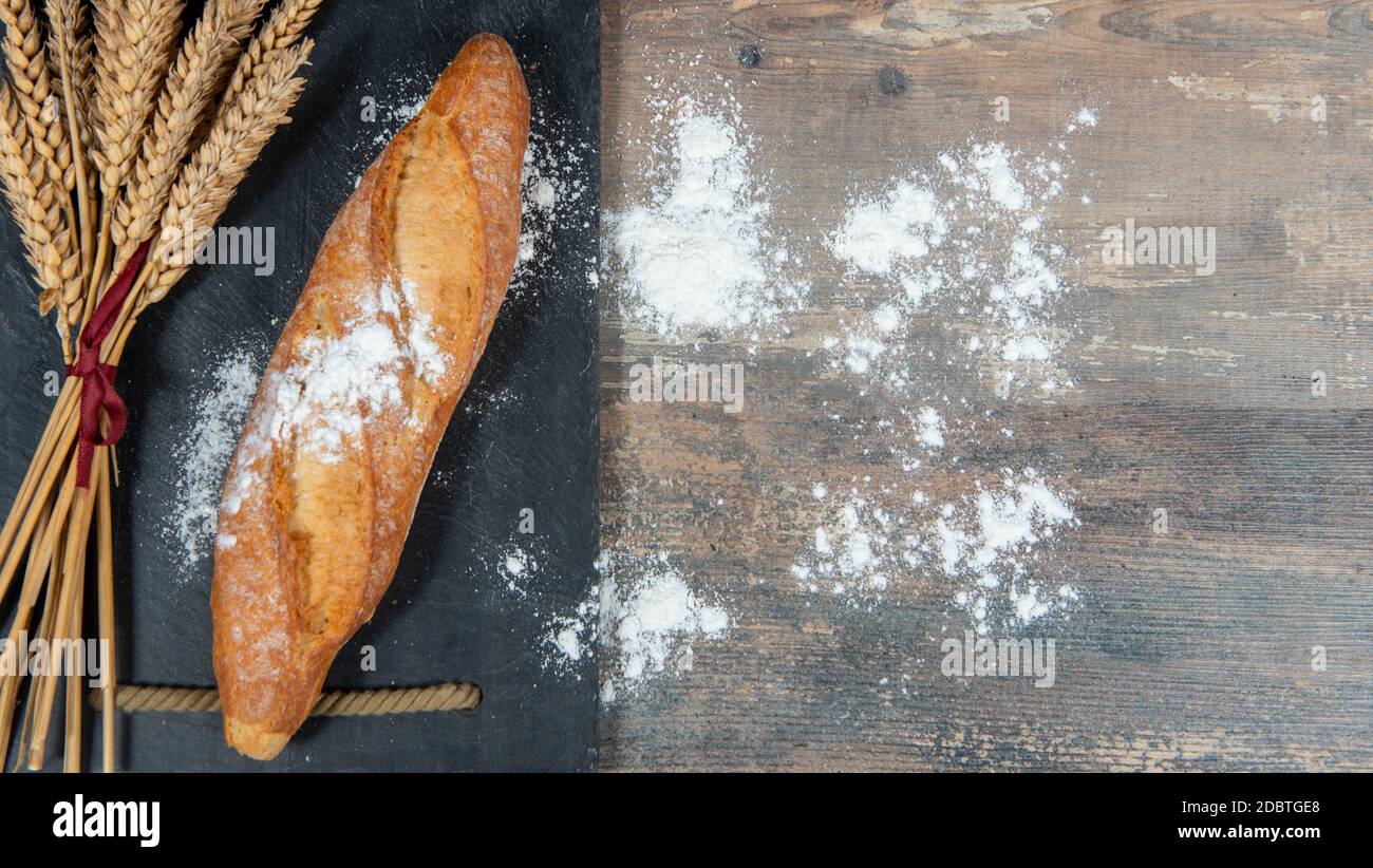 Baguette or a French bread and some wheat ears Stock Photo